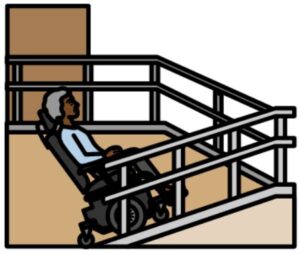 Woman in a wheelchair going up a ramp into a building