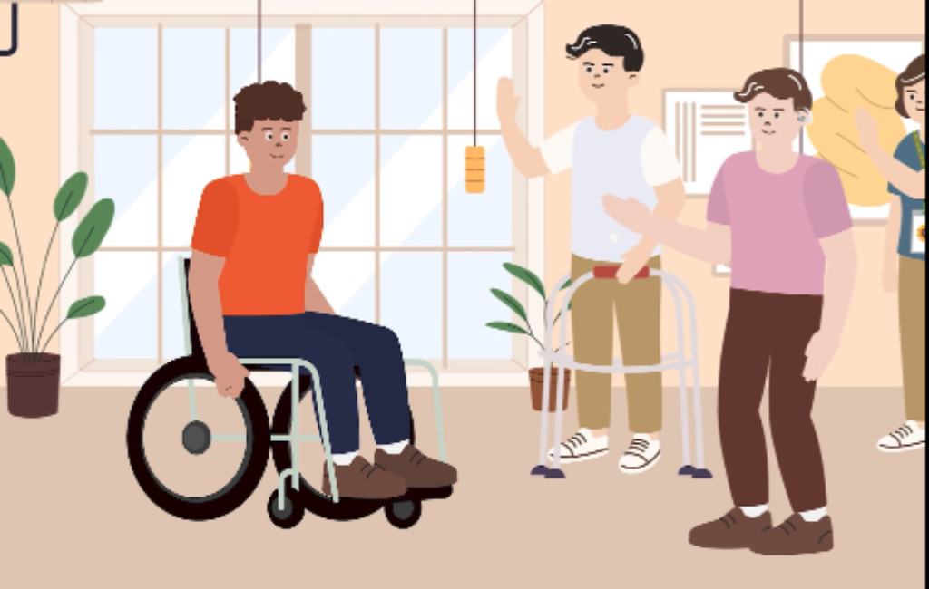 A male wheelchair user enters a room and is being welcomed by a group of people