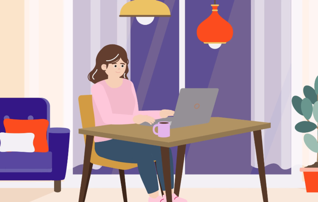 Woman sitting at her desk with a laptop emailing a peer group